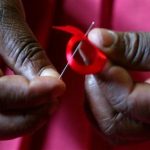 A Kenyan woman prepares ribbons ahead of December 1st, the World Aids Day at Beacon of Hope centre in ...