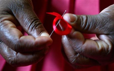 A Kenyan woman prepares ribbons ahead of December 1st, the World Aids Day at Beacon of Hope centre in ...