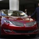 Mulally, president and CEO of Ford Motor Company, stands next to Lincoln MKZ mid-size sedan during news conference in New York