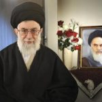 Iran's Supreme Leader Ayatollah Ali Khamenei sits next to a portrait of late leader Ayatollah Ruhollah Khomeini in Tehran