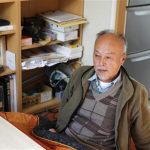Horiuchi, an evacuee from the town of Tomioka, speaks to Reuters in his temporary housing unit, in Iwaki