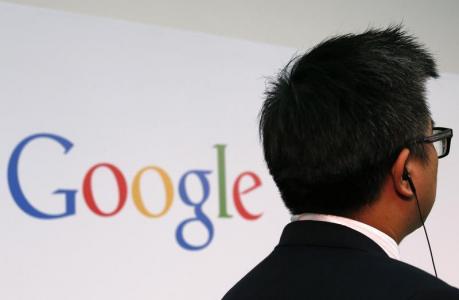 A man stands in front of a Google logo in Hong Kong