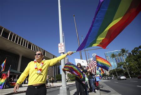 Don Fasone waves a flag in support of same sex marriage while the Hawaii State Senate convenes to approve the bill allowing same sex marriage to be legal in the state of Hawaii in Honolulu
