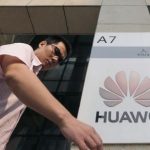 A man walks past a Huawei company logo outside the entrance of a Huawei office in Wuhan, Hubei province
