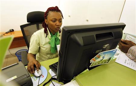 An employee registers a customer for a mobile money transfer inside the Safaricom mobile phone care centre in the central business district of Kenya's capital Nairobi