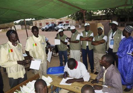 A delegation of the ECOWAS observer mission monitor the counting of cast votes at a polling station in Bamako