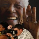 Photographers take pictures during a news conference with the cast of the biographical film "Mandela: Long Walk to Freedom" at the Nelson Mandela Centre of Memory in Johannesburg