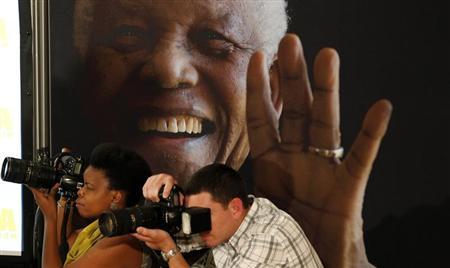 Photographers take pictures during a news conference with the cast of the biographical film "Mandela: Long Walk to Freedom" at the Nelson Mandela Centre of Memory in Johannesburg