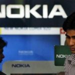 A customer speaks on his mobile phone as he comes out of a Nokia showroom in New Delhi