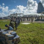Handout of sailors assigned to the aircraft carrier USS George Washington, marines from the 3d Marine Expeditionary Brigade (3d MEB), and Philippine civilians unload relief supplies that were airlifted ashore in support of Operation Damayan in Guiuan
