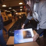 A Sony employee takes a Playstation 4 out of the box in advance of a special sale event put on by Sony at the Standard Hotel in New York