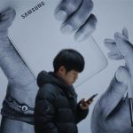 A passenger using his mobile phone walks past an advertisement promoting Samsung Electronics' Galaxy Note 3 at its exhibition hall at a railway station in Seoul