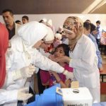 Syrian health workers administer polio vaccination to a girl at a school in Damascus