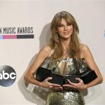 Musician Taylor Swift poses backstage with her awards at the 41st American Music Awards in Los Angeles