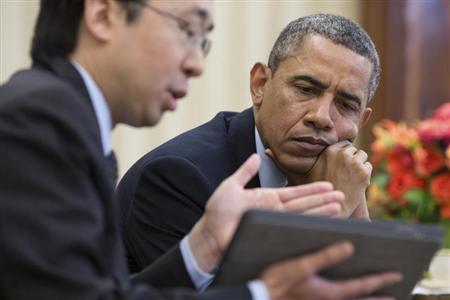 File handout photo of U.S. President Obama watches as CTO Park shows information on a tablet during a meeting in the Oval Office in Washington