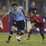 Edinson Cavani of Uruguay fights for the ball with Adnan Adous of Jordan during their World Cup qualifying playoff first leg soccer match at Amman International stadium