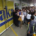 Shoppers crowd outside a Daka store as they wait to shop for electronic goods in Caracas