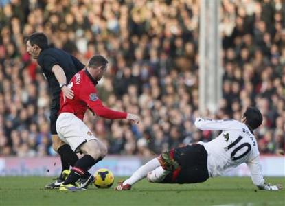 Manchester United's Rooney collides with referee Probert as he is challenged by Fulham's Ruiz during their English Premier League soccer match at Craven Cottage in London