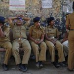 Policemen keep watch during a protest rally organised by various trade unions in Mumbai