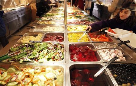 A girl helps herself to a buffet at a fast food restaurant in Harlem in New York
