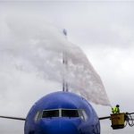 A worker from Wilson Air Center de-ices a Southwest Airlines plane before it lifts off to Orlando