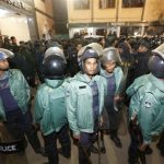 Police officers stand guard in front of the central jail in Dhaka.