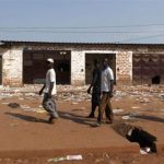Men walk past looted stores belonging to Muslims in Combattant district in Bangui