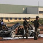 French soldiers stand guard near a burnt car from overnight clashes in Bangui