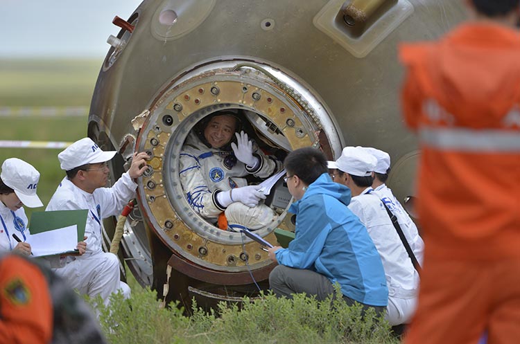 Chinese astronaut Nie waves before getting out of re-entry capsule of China's Shenzhou-10 spacecraft after it landed at its main landing site in Inner Mongolia Autonomous Region