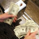 Four thousand U.S. dollars are counted out by a banker counting currency at a bank in Westminster