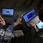 Men install Microsoft Corp's Windows 8 operating system to his laptop in Akihabara