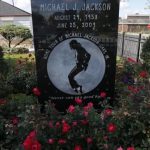 Two boys look through the fence surrounding the childhood home of singer Michael Jackson in Gary, Indiana