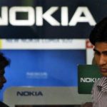 A customer speaks on his mobile phone as he comes out of a Nokia showroom in New Delhi