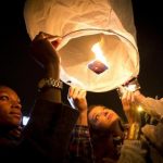 People release paper lanterns after lighting them outside a restaurant named in honor of former South African President Mandela, in the Brooklyn borough of New York