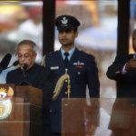 India's President Mukherjee speaks at the podium as a sign language interpreter punches air beside him during a memorial service for late South African President Nelson Mandela in Johannesburg