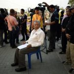 Protest leader Suthep Thaugsuban prepares to address anti-government protesters as they take part in birthday celebrations for Thailand's revered King Bhumibol Adulyadej, in Bangkok