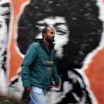 Director Yimer from Ethiopia walks past a mural in downtown Rome