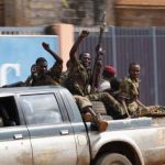 Seleka soldiers raise their fists while riding in a pick-up truck during fighting in Bangui