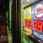 A customer arrives at a store where a Mega Millions sign is seen after the lottery grand prize rose to $344 million in New York
