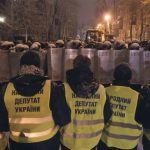 Supporters of EU integration line up in front of riot police with shields during a rally in Kiev