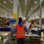 Workers handle items for delivery at Amazon's new distribution center in Brieselang