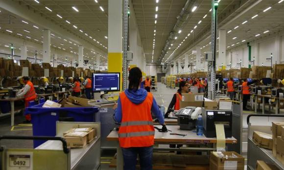 Workers handle items for delivery at Amazon's new distribution center in Brieselang