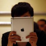 A man looks at his iPad while sitting in a cafe in central Beijing