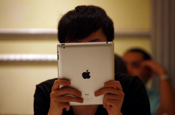 A man looks at his iPad while sitting in a cafe in central Beijing