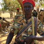 A South Sudanese soldier, with a bandolier of bullets, listens during a briefing at the army general headquarters in Juba