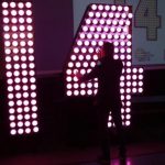A man inspects the numbers "14" lit by Phillips LED lamps that will be installed atop One Times Square to complete the "2014" sign that lights up at midnight on New Year's Eve announcing the beginning of the new year during a news conference in New York