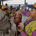 An Indian medical volunteer administers polio immunization drops