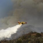 An air tanker makes waters drops as firefighters battle a fast-moving California wildfire, so-called the "Colby Fire", in the hills of Glendora