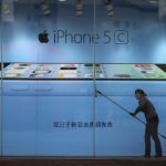 File picture shows a worker cleaning in front of an iPhone 5C advertisement at an apple store in Kunming