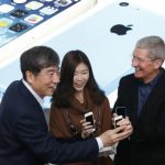 Apple Inc. CEO Tim Cook and China Mobile's Chairman Xi Guohua pose with a customer at an event celebrating the launch of Apple's iPhone on China Mobile's network in Beijing